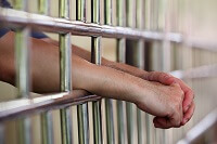 Hands hanging out of jail cell